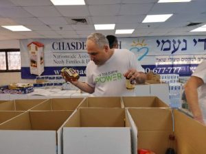 An employee from Electra Power makes sure that all the products are in the Rosh Hashanah basket